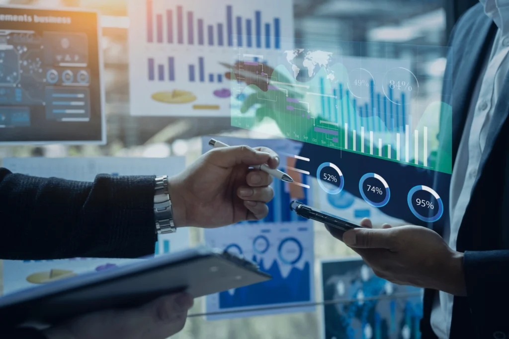 Zwei Geschäftsleute analysieren digitale Kennzahlen-Dashboards mit Diagrammen und Prozentwerten auf einem transparenten Display