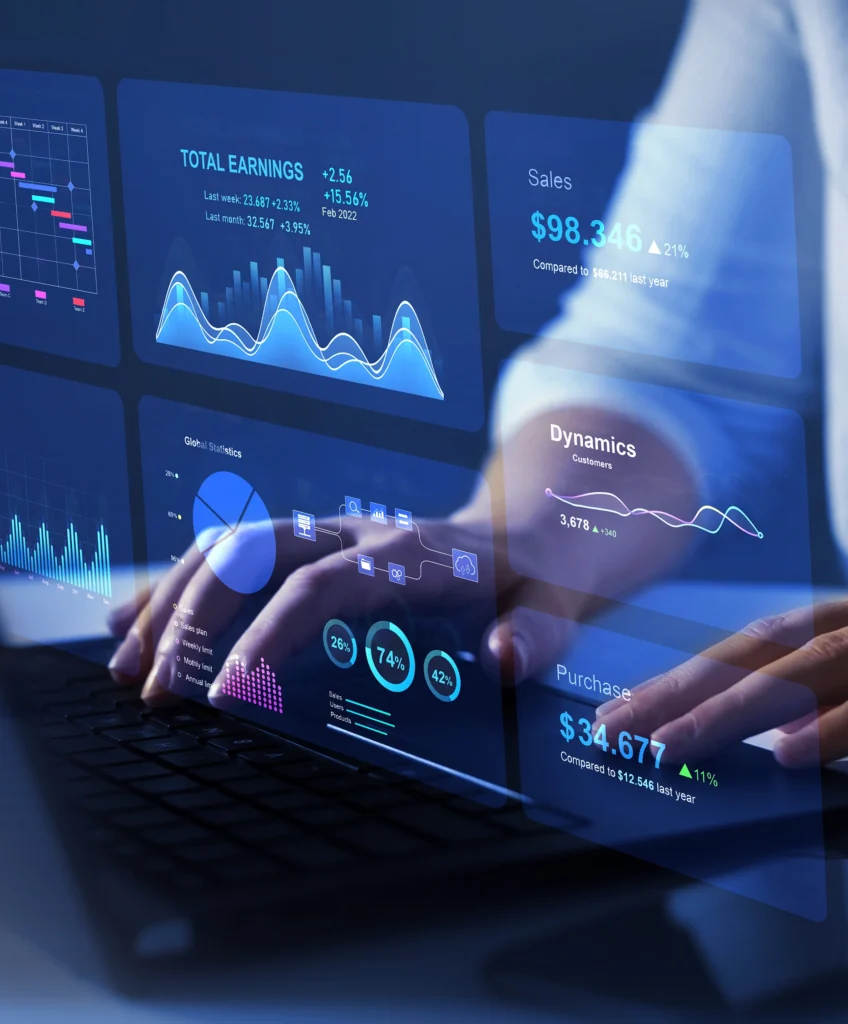 Hände an einer Laptop-Tastatur mit eingeblendeten Analytics-Dashboards, Kennzahlen und Diagrammen